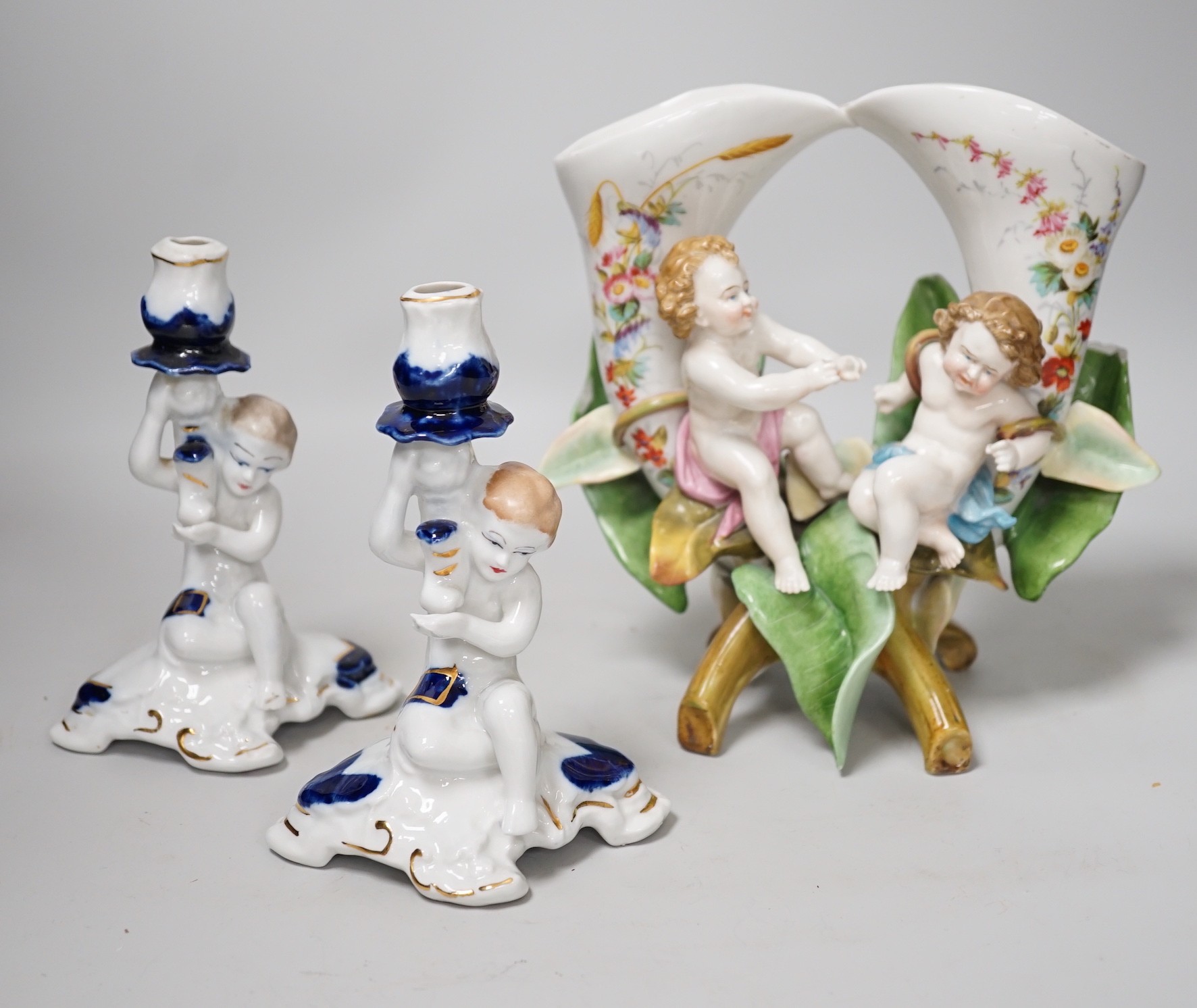 A pair of candlesticks and a figure group flower vase. Tallest 20cm